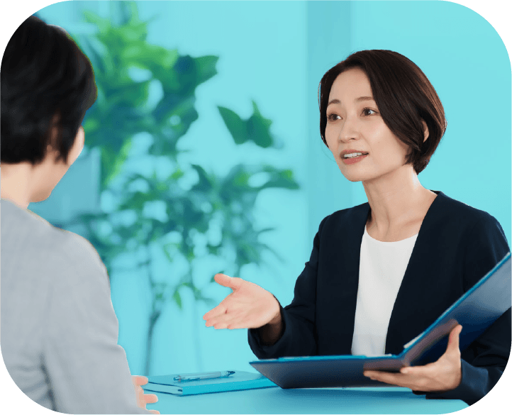 ビル街を背景に爽やかな表情で立つスーツ姿のビジネスパーソンのポートレート