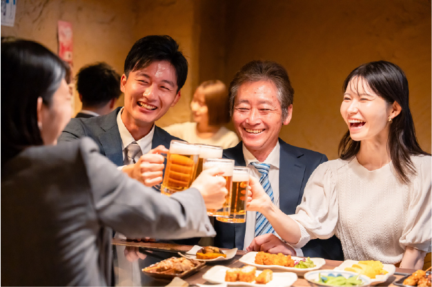 バーベキュー交流会で食事を囲みながら笑顔で談笑する社員の様子、社内表彰式で登壇者のプレゼンテーションを聞く社員の様子、懇親会で乾杯しながら和やかに交流する社員の様子、打ち上げの席でグラスを手に会話を楽しむ社員の様子