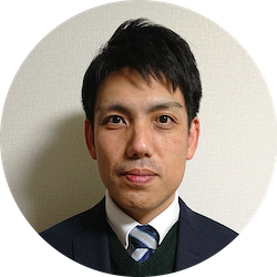 社員のプロフィール写真。スーツ姿で正面を向いて写っている人物